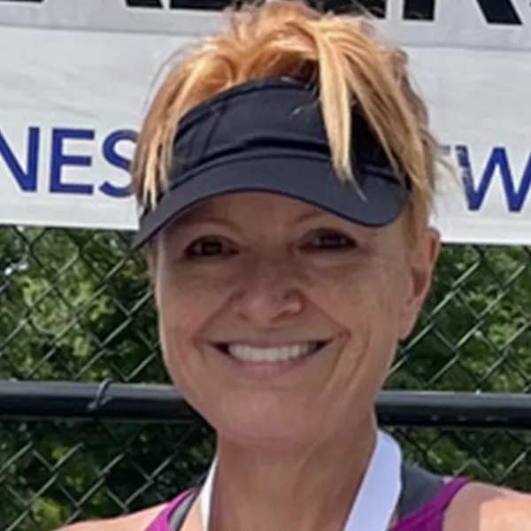 Portrait of Michele Baratt smiling and wearing a visor